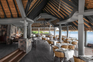 Restaurace pod širým nebem s&nbsp;doškovou střechou, elegantními bílými ubrusy a&nbsp;proutěnými židlemi s&nbsp;výhledem na&nbsp;malebné nábřeží se svěží zelení. Atmosféra je světlá a&nbsp;příjemná.