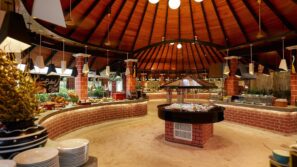 Prostorná bufetová restaurace s&nbsp;pískem pokrytou podlahou, cihlovými pulty a&nbsp;vysokým dřevěným stropem. Jídelní stanice jsou uspořádány do&nbsp;kruhu, v&nbsp;popředí jsou zavěšená světla a&nbsp;naskládané talíře.