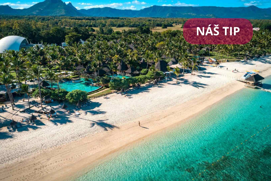Letecký pohled na&nbsp;tropickou pláž s&nbsp;bílým pískem, tyrkysovou vodou, palmami a&nbsp;letoviskem. V&nbsp;pozadí jsou vidět hory a&nbsp;bujná zeleň. V&nbsp;pravém horním rohu je červený štítek s&nbsp;českým textem NÁŠ TIP.
