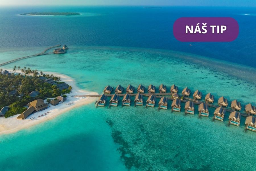 Letecký pohled na&nbsp;bungalovy nad vodou a&nbsp;písečnou pláž obklopenou průzračným tyrkysovým oceánem. V&nbsp;pravém horním rohu je fialovou bublinou napsáno NÁŠ TIP. Je vidět bujná zeleň a&nbsp;dřevěné chodníčky.