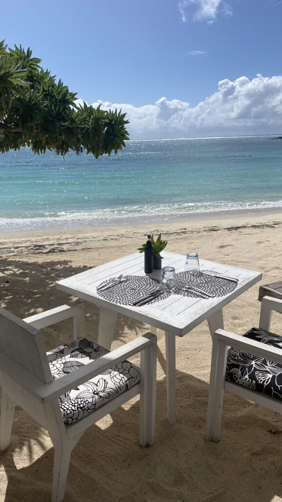 Pláž Belle Mare Mauricius s&nbsp;bílým pískem a&nbsp;výhledem na&nbsp;moře u&nbsp;obědového stolu u&nbsp;hotelu Constance Belle Mare.