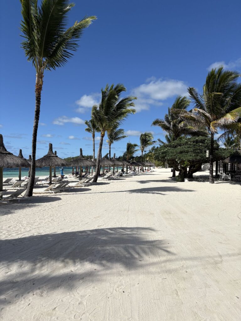 Pláž Belle Mare Mauricius s&nbsp;bílým pískem a&nbsp;lehátky u&nbsp;hotelu Long Beach Belle Mare.