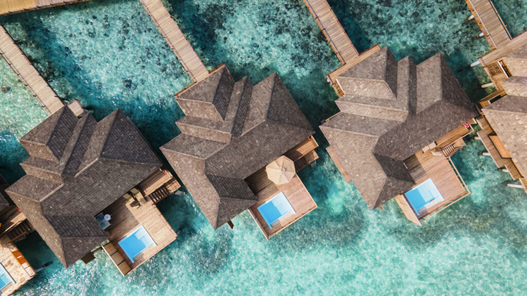 Pohled shora na&nbsp;řadu vodních vil Horizon v&nbsp;Sun Siyam Iru Fushi, každá s&nbsp;vlastním bazénem a&nbsp;proskleným průhledem do&nbsp;moře na&nbsp;terase.